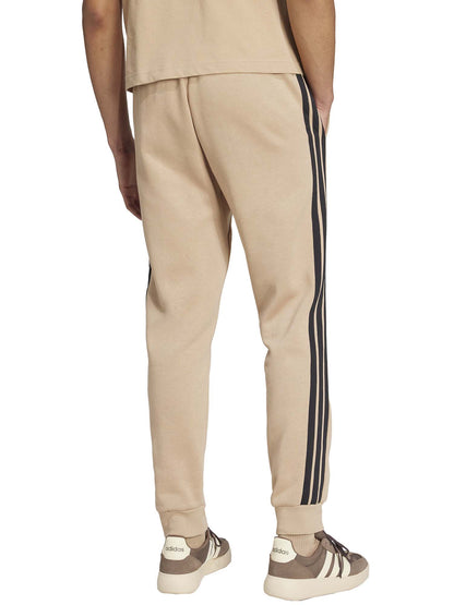 PANTALONE TUTA ESSENTIALS 3-STRIPES FLEECE ADIDAS DA UOMO NOCCIOLA